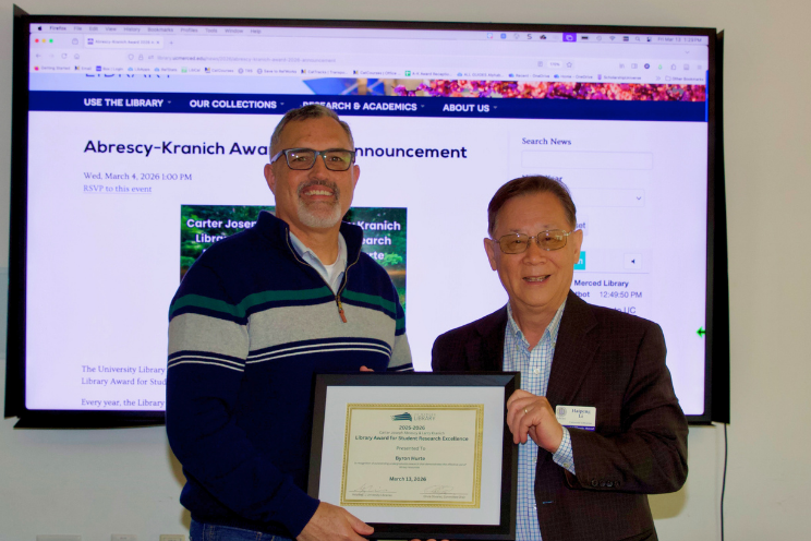 Byron Hurte, research award winner and Haipeng Li, University Librarian, hold framed award certificate