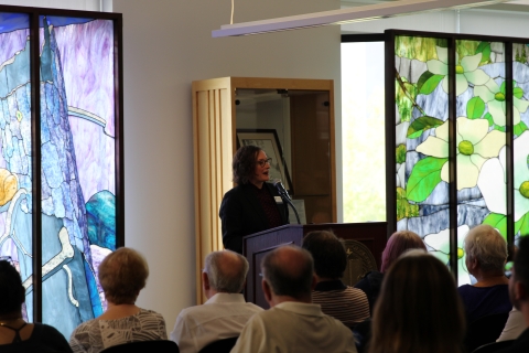 University Librarian Sarah Forzetting speaks at podium to seated crowd
