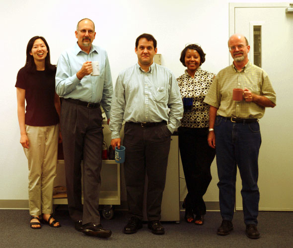 Five founding staff at the UC Merced Library, standing in a row and smiling